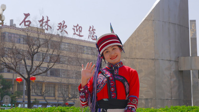 个人商用，石林欢迎您大字下县城中心街特色地标前身穿阿诗玛民族服装的女孩，视频素材